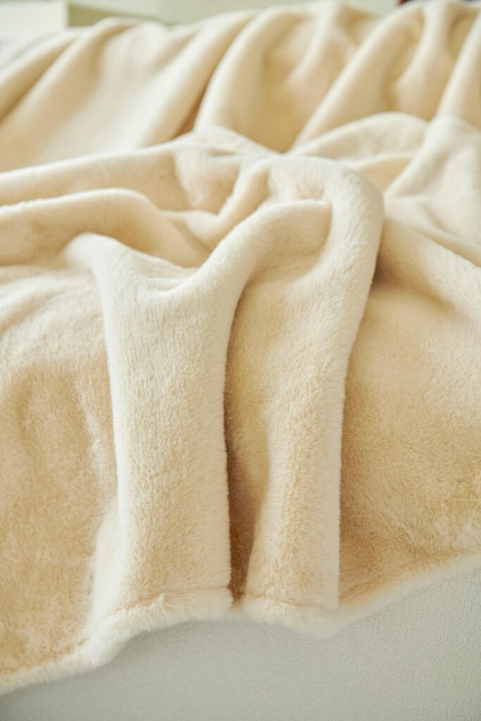 pexels-photo-30380667-30380667 Soft beige fleece throw blanket draped on a sofa, perfect for cozy home decor.